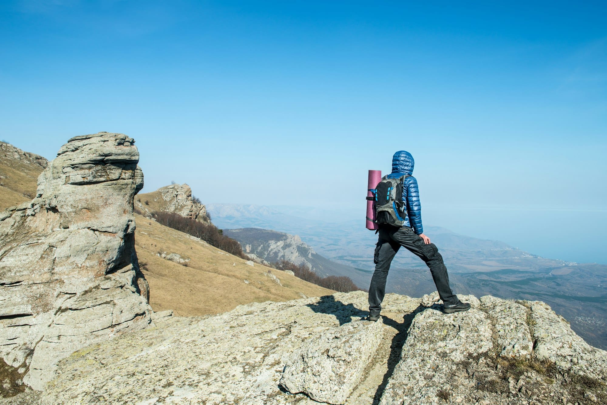 Traveler with backpack on the top of the mountain
